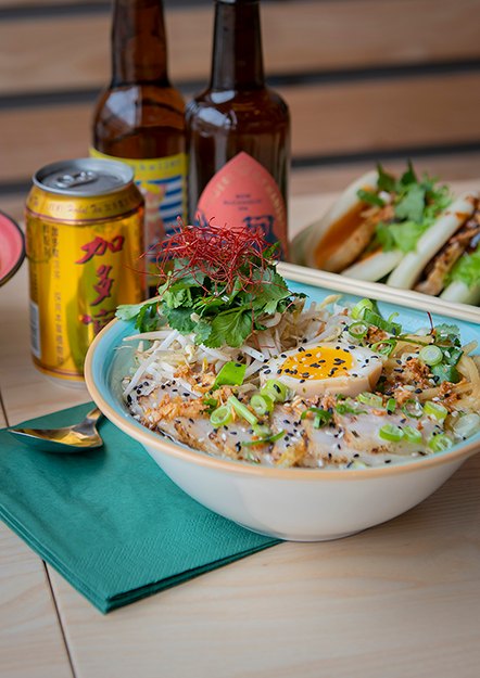 Kimli Tonkatsu-ramen med soyamarinerat ägg, bao i bakgrunden